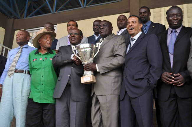FKF Chairman Sam Nyamweya receives the trophy from Ex-international captain Eli Adero following Kenya's win over their Tanzanian counterparts.